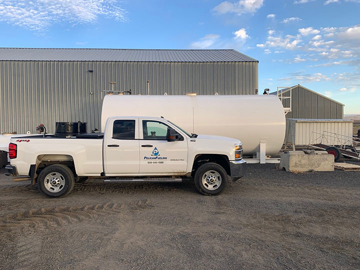 Bulk Fuel - Pelican Fuel Pickup Truck Next To Large Cylinder Tank